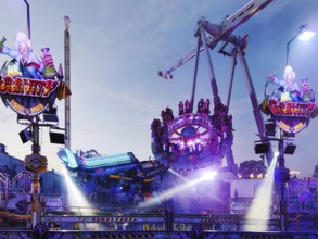 People on the illuminated carousel Mr Gravity in the evening, Cranger Kirmes, Herne, Ruhr area,