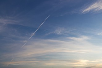 Blue sunset sky with trace of the plane