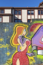 Colourful graffito of a woman with a gun, street art in the city of Punta Arenas, Patagonia, Chile,