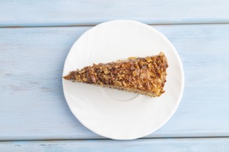 Walnut and hazelnut cake with caramel cream on blue wooden background. top view, flat lay, copy