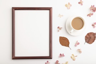 Composition with wooden frame, brown beech autumn leaves, hydrangea flowers and cup of coffee.