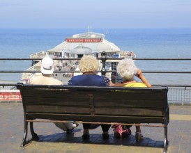 People looking out to sea above the pier at Cromer, Norfolk, England, UK