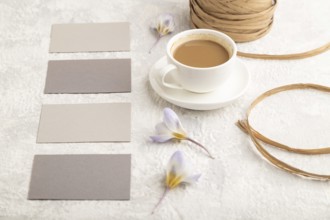 Gray paper business card mockup with spring snowdrop crocus flowers and cup of coffee on gray