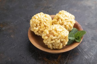 Traditional Tatar candy chak-chak made of dough and honey in wooden plate on a black concrete