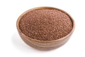 Wooden bowl with raw red quinoa seeds isolated on white background. Side view, close up