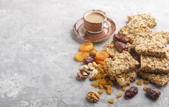 Homemade granola from oat flakes, dates, dried apricots, raisins, nuts with a cup of coffee on a