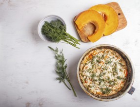 Sweet pumpkin pie with cheese and dill on white wooden background. top view