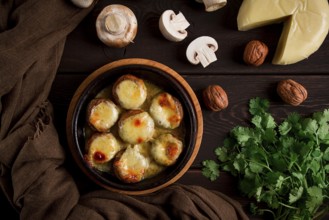 Traditional Georgian dish, appetizer, stuffed mushrooms, Sulguni cheese, baked in a Ketzi clay pan,