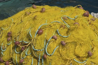 Yellow fishing nets with ropes and floats, harbour of Symi, Dodecanese, Greek Islands, Greece,