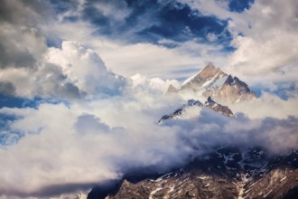 Snowcapped summit top of mountain in Himalayas in clouds. Sangla, Himachal Pradesh, India, Asia