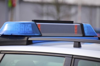 Symbolic image: Close-up of a police car with flashing blue lights