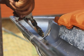 Roofer doing tinsmith work on a gutter