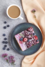 Berry cake with milk cream and blueberry jam on blue ceramic plate with cup of coffee and fresh