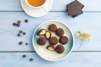 Japanese rice sweet buns chocolate mochi filled with cream and cup of green tea on blue wooden