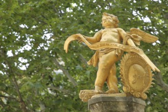 Sculpture golden angel at the fountain, putto with ribbon and coat of arms, golden, child, detail,