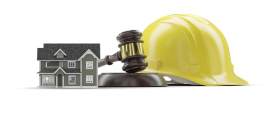 Miniature model house, yellow hard hat and gavel isolated on a white background