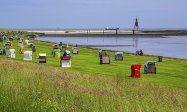 Grassy beach on the dyke with beach chairs and landmark Kugelbake in the district of Grimmershörn,