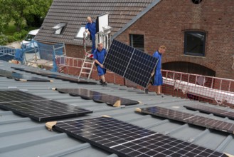 Installation of solar modules on the roof of a barn on a farm, over 240 photovoltaic modules are