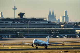 Aeroplane taking off at Cologne-Bonn Airport, Terminal 1 building, skyline with Cologne Cathedral