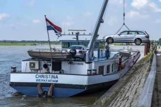 Inland waterway transport, a bargeman's vehicle is loaded from the shore onto the cargo ship with