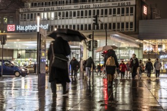 Passers-by at a pedestrian crossing, at the main railway station, rainy weather, city centre, in