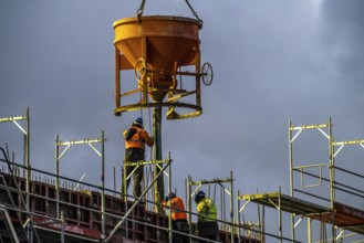 Concrete work, at dusk, on a large construction site building a residential and commercial complex,