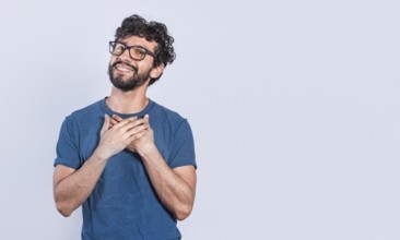 Grateful people smiling with hands on chest. Positive looking friendly handsome man with charming