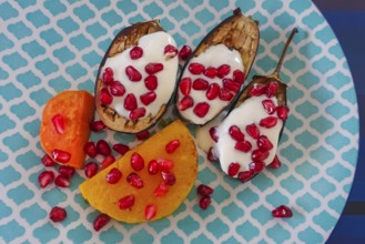 Mediterranean cuisine, roasted aubergines with pomegranate seeds and yoghurt, sweet potatoes,