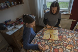 Two sisters playing the parlour game Mensch Ärgere Dich nicht, Mecklenburg-Vorpommern, Germany,