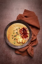 Pumpkin cream soup, curry, fried bacon, bruschetta chips, micro-greens, top view, no people