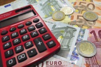 Euro banknotes and coins and pocket calculator