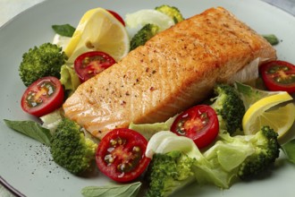 Grilled salmon fillet, with vegetables, broccoli, cherry, iceberg lettuce, spices and herbs,