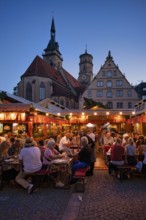 People sitting in vine arbours in the evening, wine village Stuttgart, Schillerplatz, collegiate