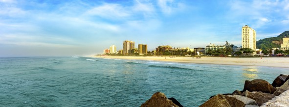 Panoramic photograph of Barra da Tijuca beach seen from the breakwater pier at dawn in the city of