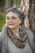 Portrait of elderly woman, 65 years old, enjoying nature in the forest in Ystad, Skåne, Sweden,