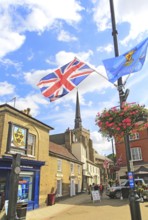 Flags frame view of spire St Peter and St Mary church in town centre, Stowmarket, Suffolk, England,