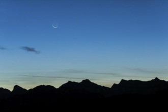 Crescent moon over mountain silhouette, Valais, Swiss Alps