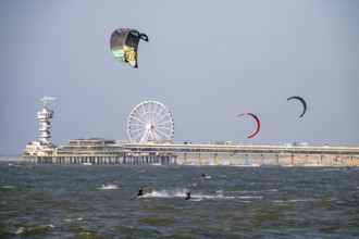 The pier and Ferris wheel at Scheveningen beach, strong swell, windsurfers, kitesurfers,