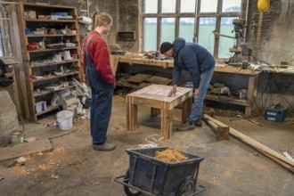 Father and son looking at the table built by the son in the workshop, Mecklenburg-Vorpommern,