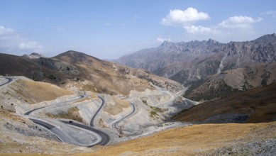 Winding roads on the Pamir Highway, mountain road through an eroded mountain landscape, Kyrgyzstan,