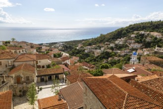 View to Ionian Sea over houses and rooftops with Greek Orthodox Church of Saint Spyridon, village