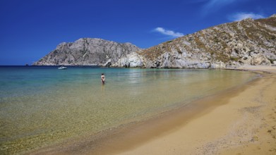 A quiet beach with turquoise waters, surrounded by mountains under a clear sky, Psili Ammos Srand,