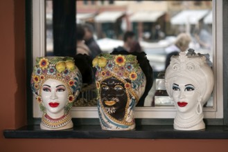 Decorative vases designed with Indian faces, in the window of an Indian restaurant, Portofino,