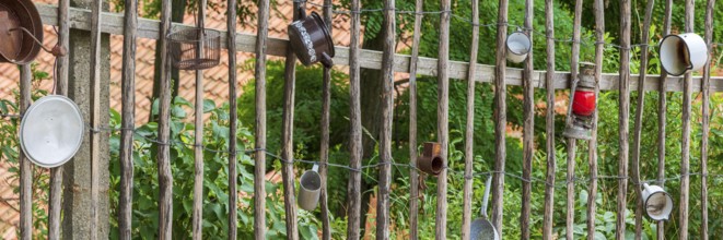 Traditional wooden fence, farm fence, decorated with old pots and utensils, rural idyll, country