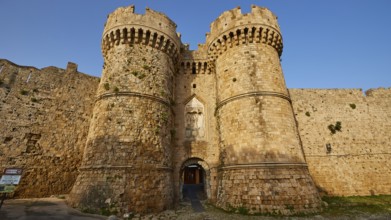 Two towers of a fortress in the warm morning light with shadows on the wall, sea gate, harbour