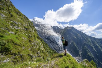 Mountaineer in front of impressive mountain landscape with glacier, view of glacier Glacier de