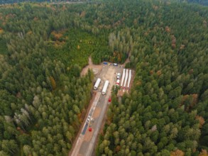 Aerial view of a construction site in the forest with distributed components for a wind turbine in