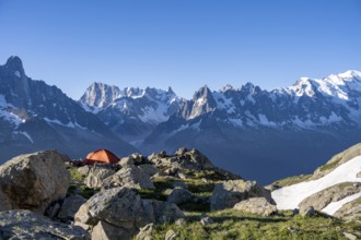 Red tent in front of a mountain panorama, mountain landscape in the morning light, mountain peaks