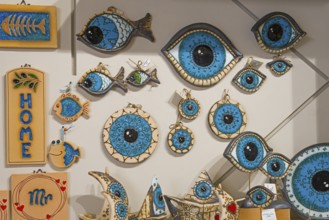 Ceramic wall decoration with blue eye motifs and fish on a beige background, Nazar amulets,