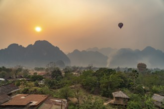 Hot air balloon at sunrise in the landscape of Vang Vieng, Laos, Asia